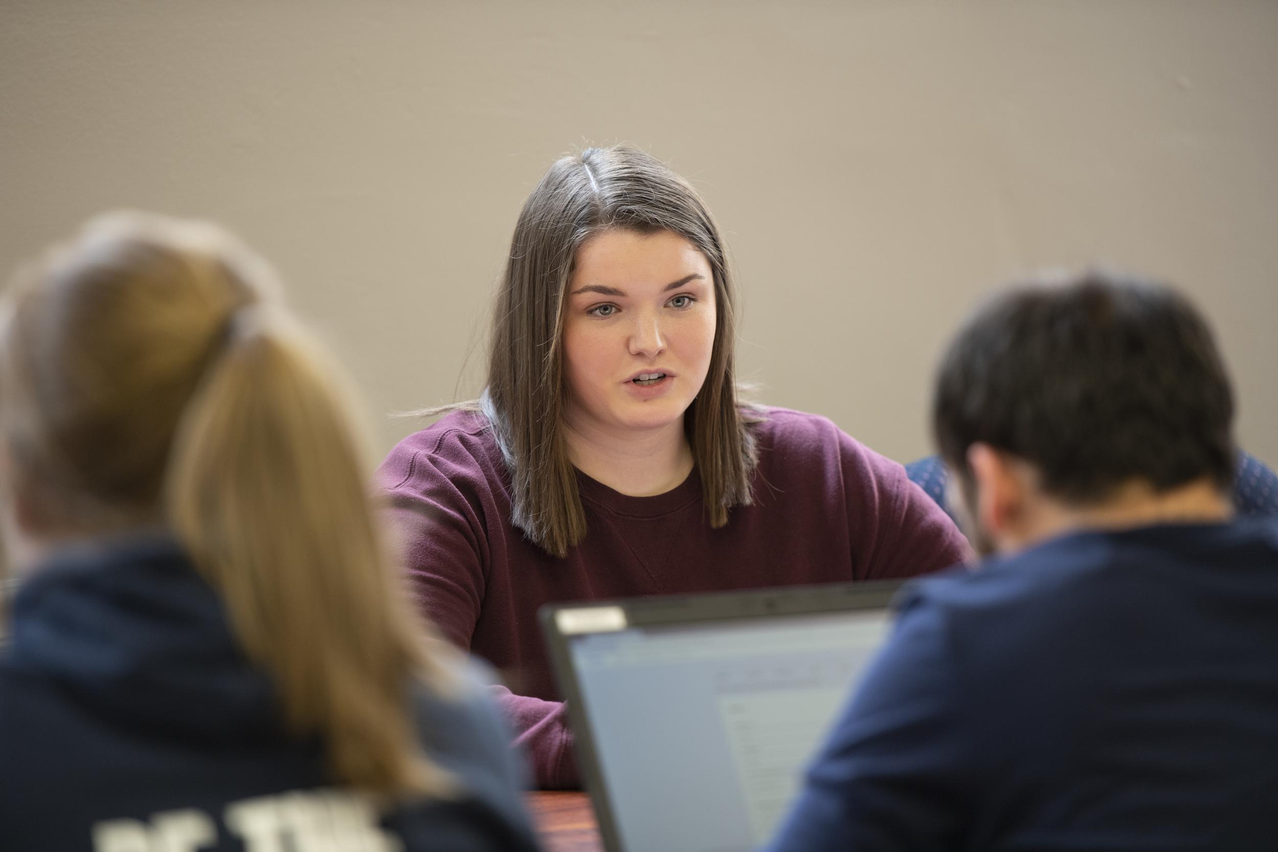 woman sitting across from two other people having a discussion