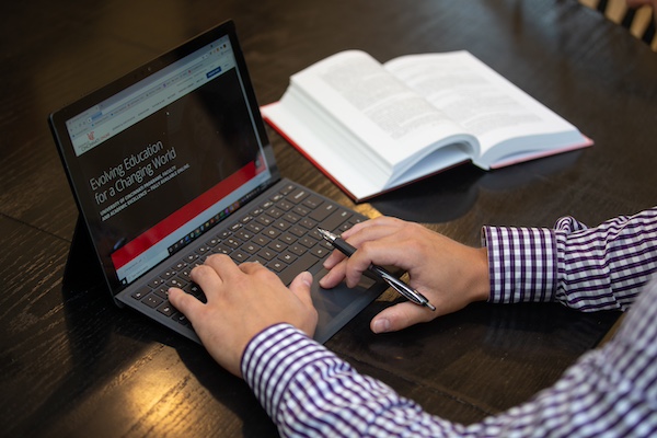 someone sitting in front of a laptop typing